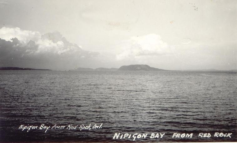 [caption on back]

The picture is taken from our camp which is on the West side of the lake.  The Land which you see in the centre of the picture is an island &amp; if you were in a boat &amp; kept bearing around to the right for about 100 miles it would take you to Port Arthur &amp; Fort William.