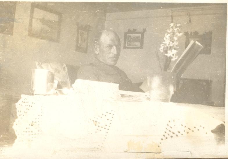 John McLurg reading newspaper during internment as P.O.W., Mürren, Switzerland, 1916-1917.